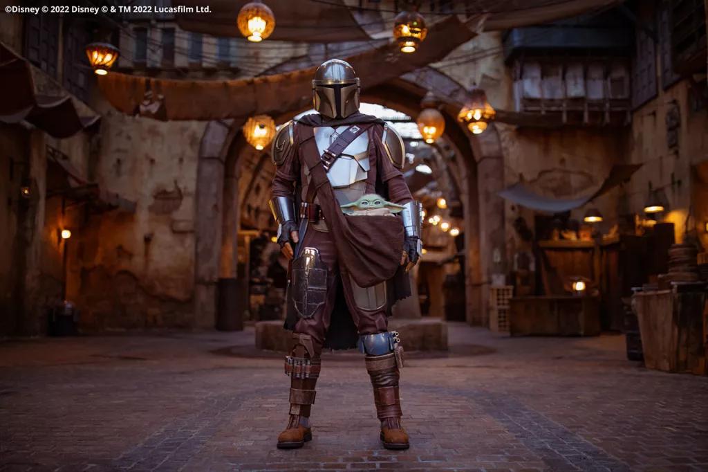 The Mandalorian wearing full armour standing in Star Wars: Galaxy's Edge
