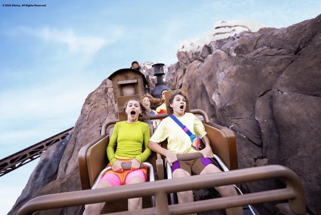 A young boy and girl screaming on a rollercoaster