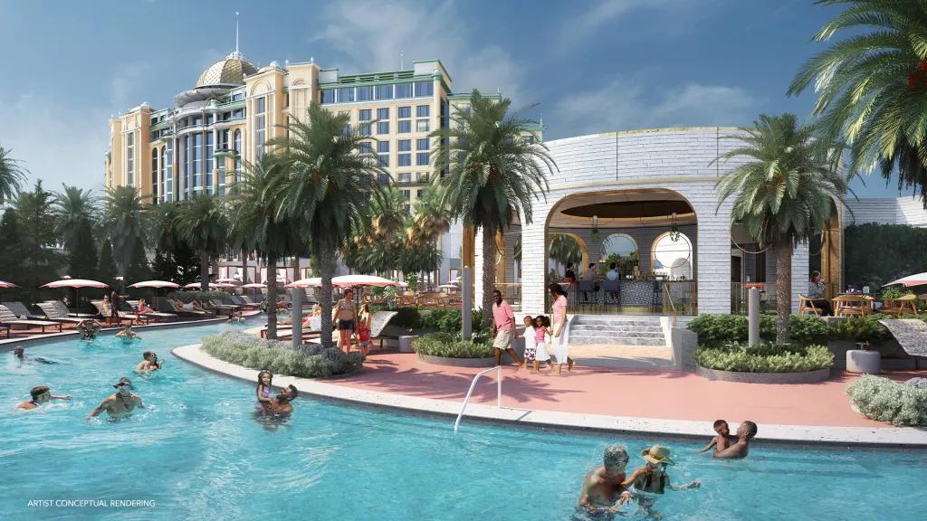 A large, clear water pool with many families and people swimming in it. Next to the pool there is a circular shaped building with a bar inside. In the background there is a large white hotel.