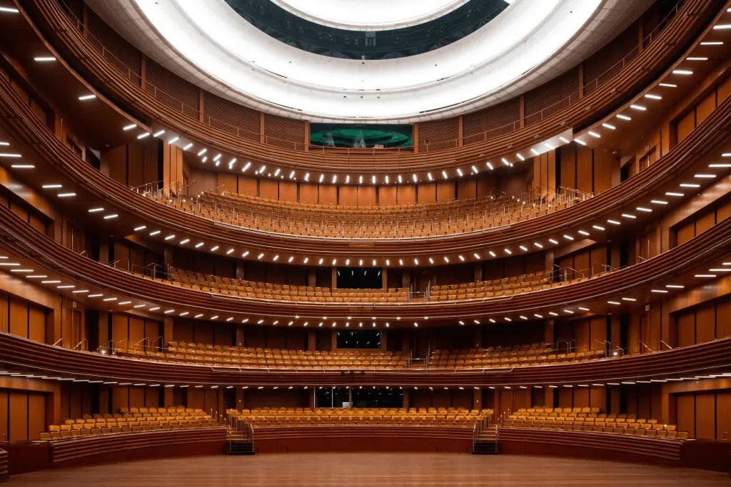 Circle theatre coloured brown with theatre chairs and an empty stage.