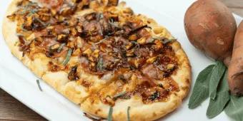 Eine lange Pizza, belegt mit herbstlichen Zutaten