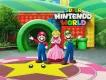 An artist rendering of Mario, Luigi and Princess Peach standing in front of the entrance to Super Nintendo World at Universal Studios Hollywood