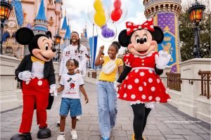 Mickey Mouse, Minnie Mouse, and a family walking in front of a Disney castle