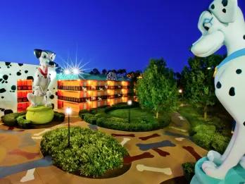 On the floor there are dog bone images printed next to large circular plant pots. There are also two large dalmatian statues based off of the movie 101 dalmatians. Behind there are hotel buildings which are orange.