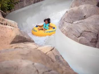A young girl on a raft going down a water slide