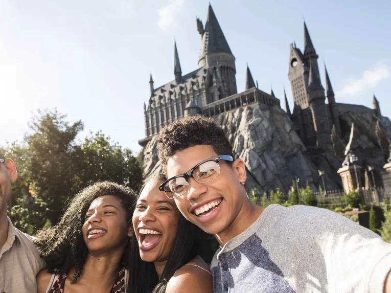 Family taking selfie in front of Hogwarts Castle at Universal's Islands of Adventure