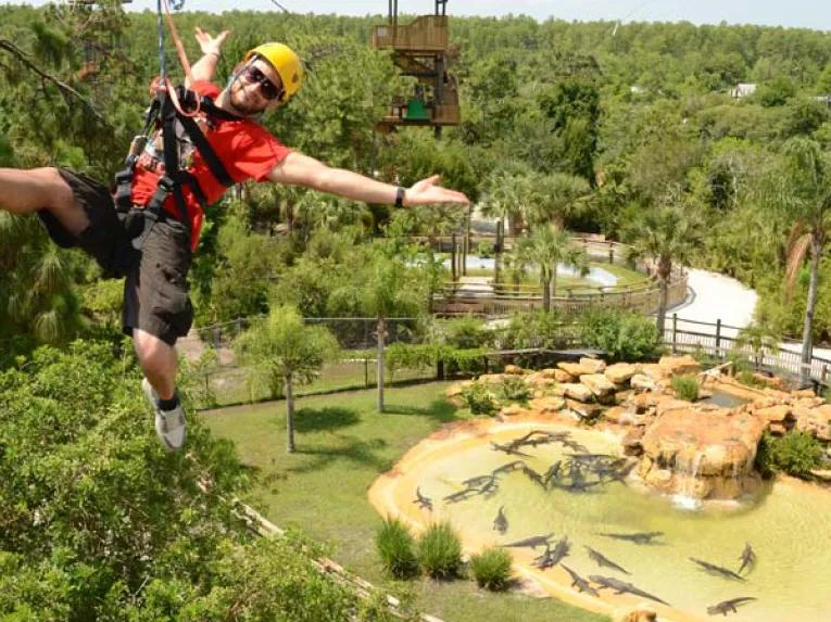 Man riding the Screamin’ Gator Zip Line at Gatorland