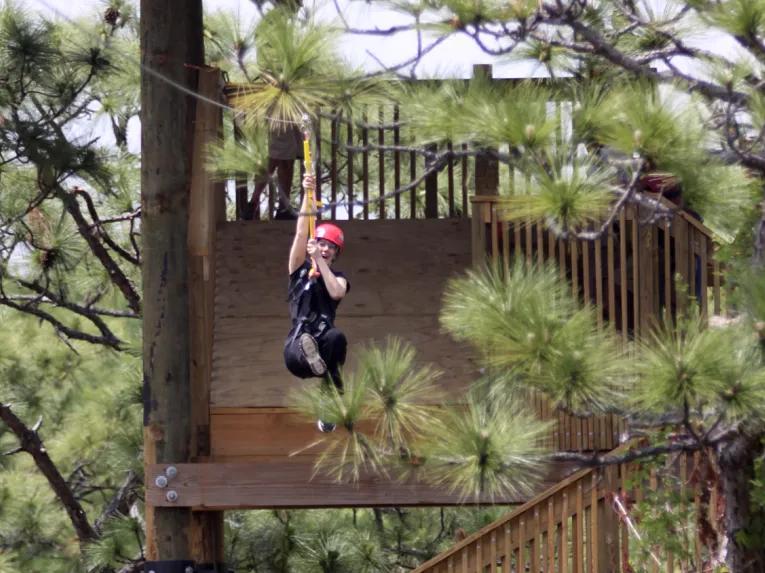 woman riding the Screamin’ Gator Zip Line at Gatorland