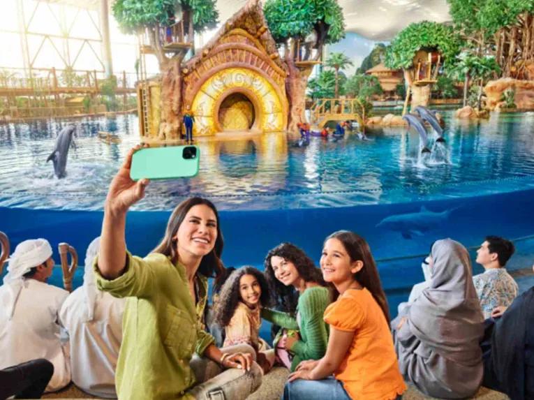 Smiling people taking a selfie at the Dolphin Presentation at SeaWorld Yas Island Abu Dhabi
