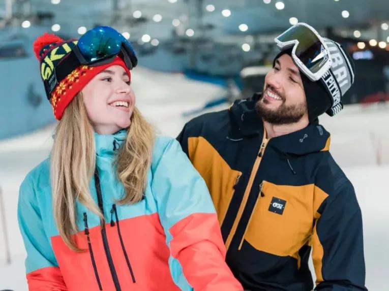 Happy couple in ski clothing enjoying the indoor slopes at Ski Dubai